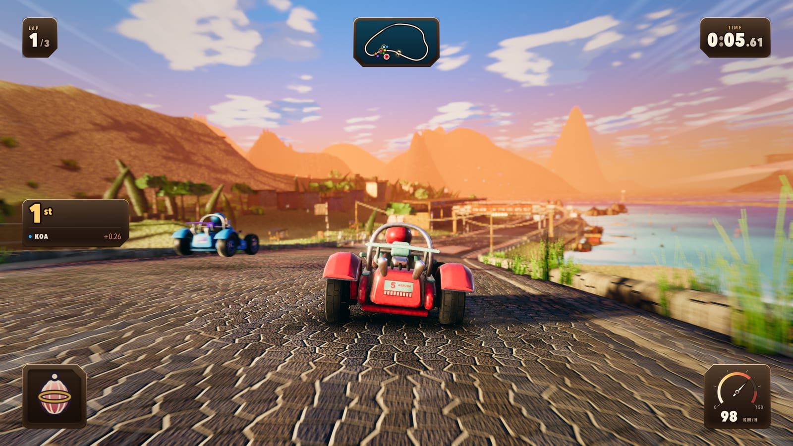 Two karts crossing a cobbled bridge above the bay, a jetty and moored boats below and terracotta cliffs across the water.