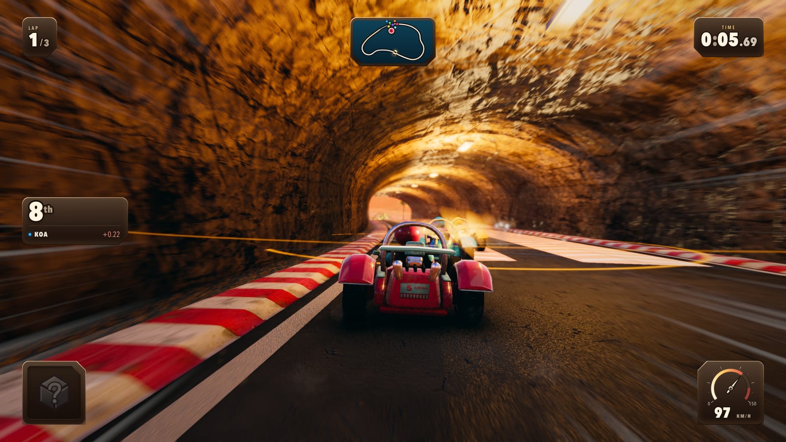 A kart in a rock tunnel lit warm from the far mouth, kerb streaking past at speed.
