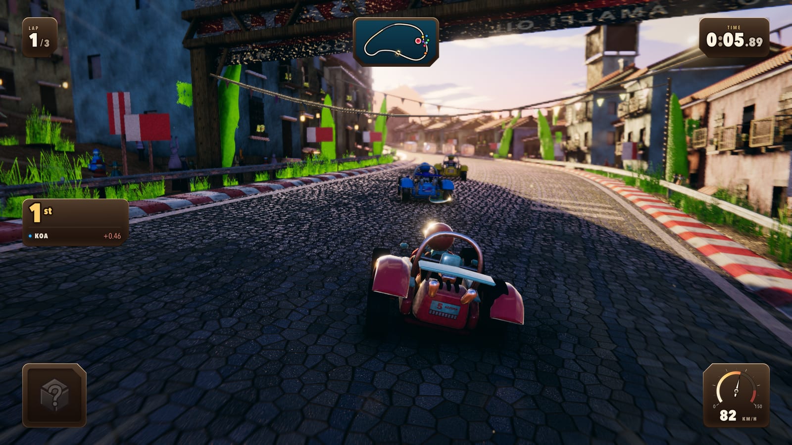 Karts running a cobbled village street under a banner arch, bunting and washing lines strung between pastel houses.